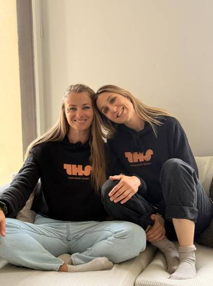 The duo in matching THS hoodies on a sofa