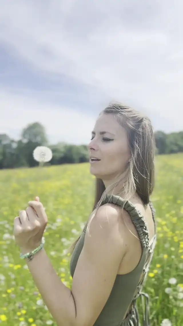 Blowing a dandelion in a summer meadow